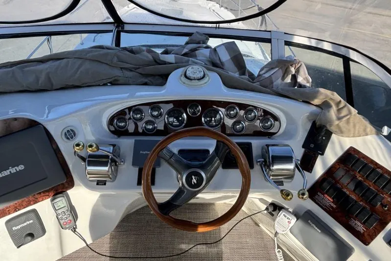Gazoo Yacht Photos Pics 2001 Sea Ray 400 Sedan Bridge helm with gauges, controls, and wooden steering wheel.