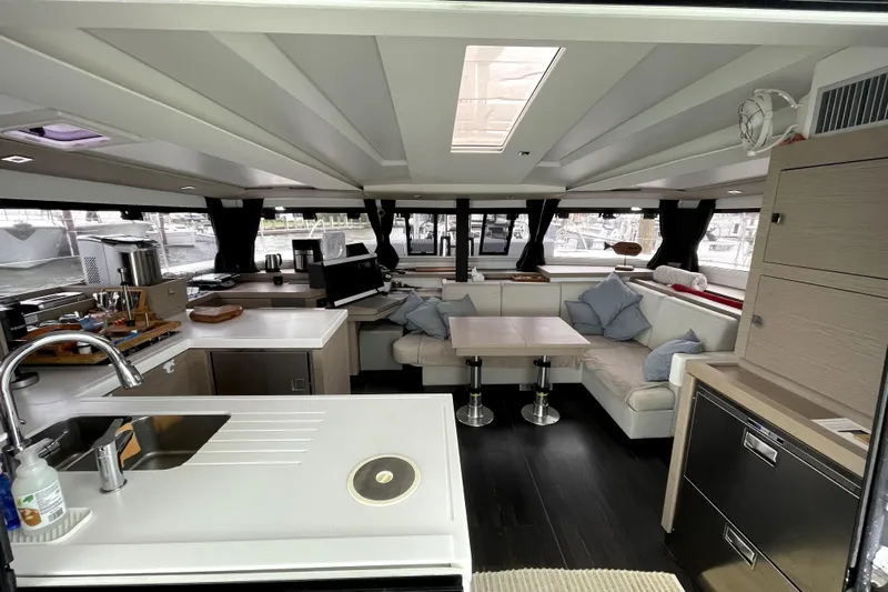 No Brainer Yacht Photos Pics Luxurious interior of 2022 Fountaine Pajot Astrea 42 catamaran with modern kitchen and seating area.
