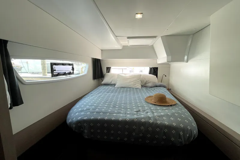 No Brainer Yacht Photos Pics Cozy bedroom in 2022 Fountaine Pajot Astrea 42 yacht with window view and straw hat.
