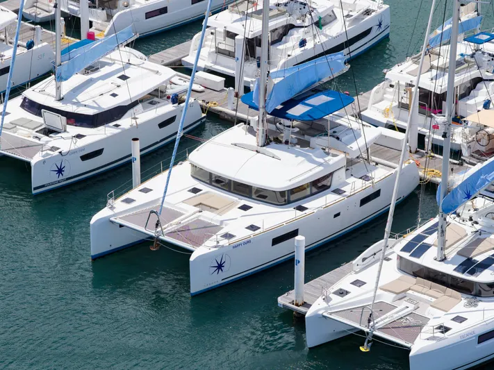 Happy Ours Yacht Photos Pics Aerial view of 2022 Lagoon 52 F catamarans docked in a marina.