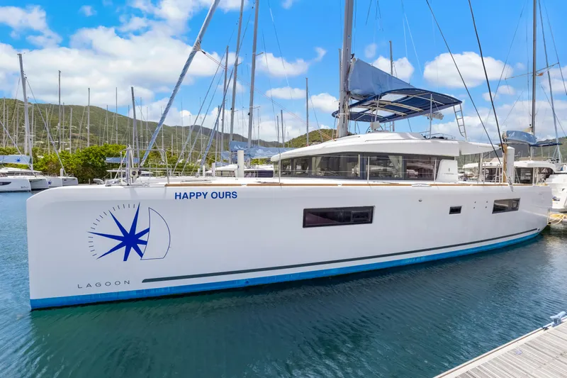 Happy Ours Yacht Photos Pics 2022 Lagoon 52 F catamaran docked in a marina, clear sky, and scenic background.