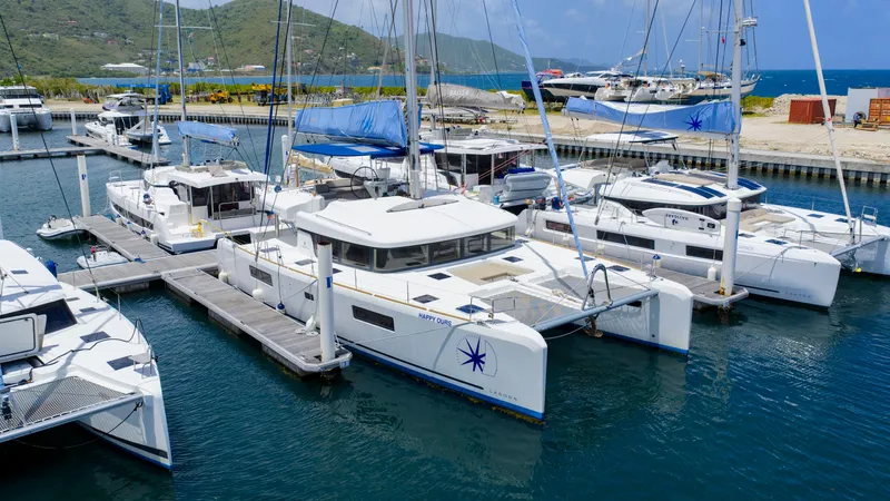 Happy Ours Yacht Photos Pics Docked Lagoon 52 F catamarans, 2022 model, in a scenic marina setting.