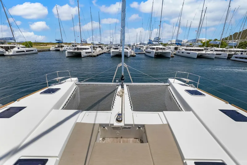 Happy Ours Yacht Photos Pics 2022 Lagoon 52 F catamaran docked in a marina with other sailboats.