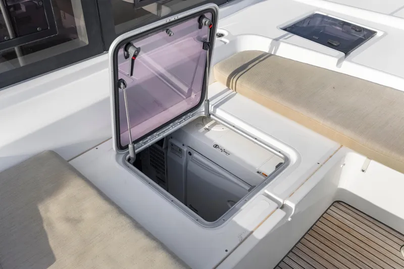 Happy Ours Yacht Photos Pics Open hatch on 2022 Lagoon 52 F catamaran deck, revealing storage compartment.