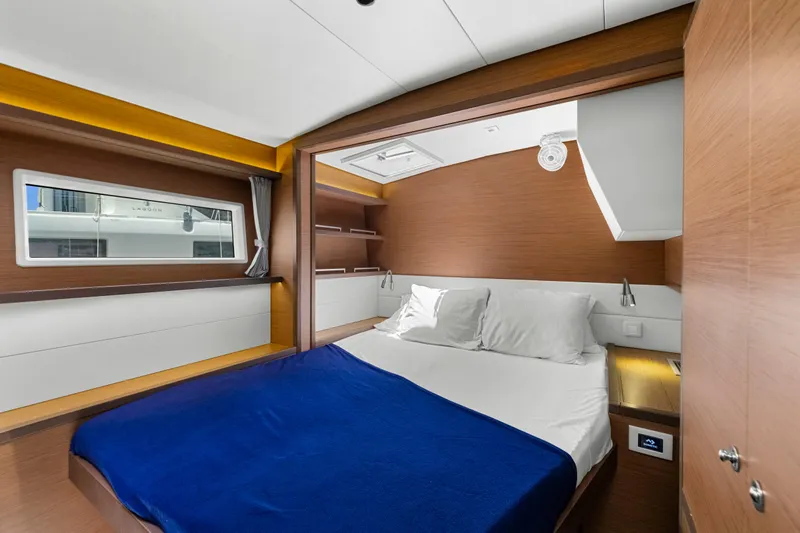 Happy Ours Yacht Photos Pics Luxurious cabin interior of 2022 Lagoon 52 F yacht with modern design and cozy bedding.