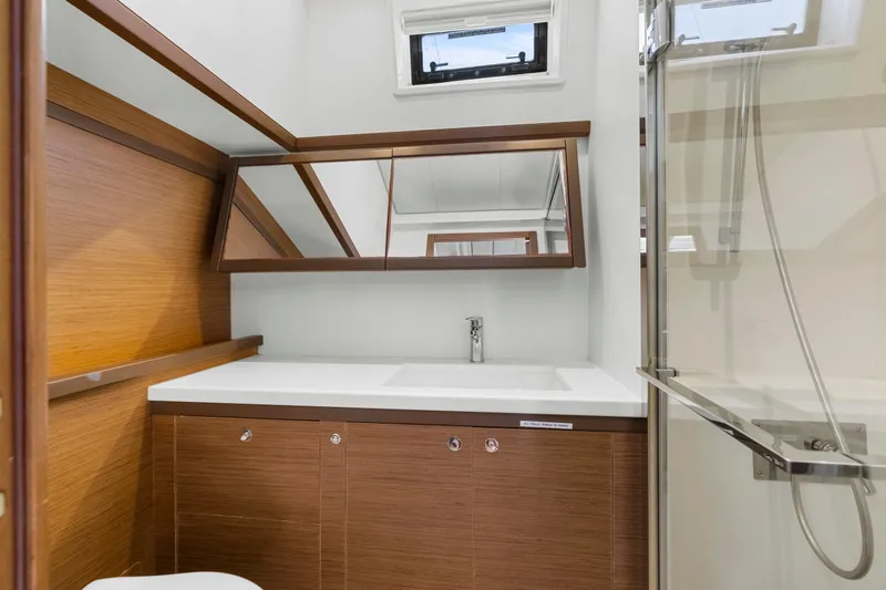 Happy Ours Yacht Photos Pics Modern bathroom interior of 2022 Lagoon 52 F yacht, featuring wood accents and sleek fixtures.
