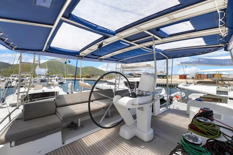 Happy Ours Yacht Photos Pics Luxurious 2022 Lagoon 52 F yacht interior with helm, seating, and marina view.