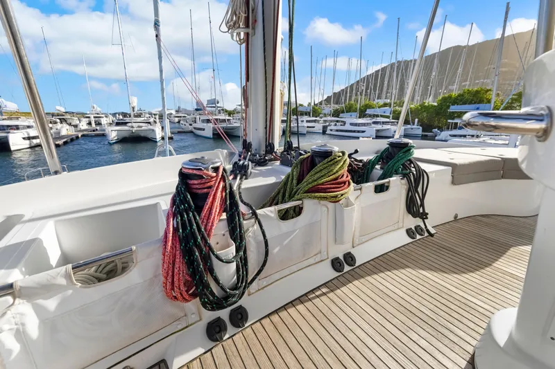 Happy Ours Yacht Photos Pics Lagoon 52 F 2022 yacht deck with ropes, docked in a marina under blue skies.
