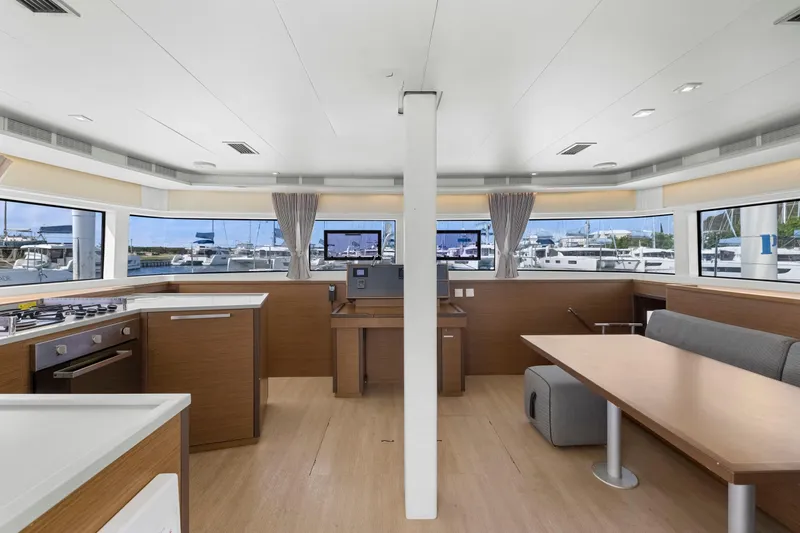 Happy Ours Yacht Photos Pics Interior of 2022 Lagoon 52 F catamaran with modern kitchen and dining area, marina view.