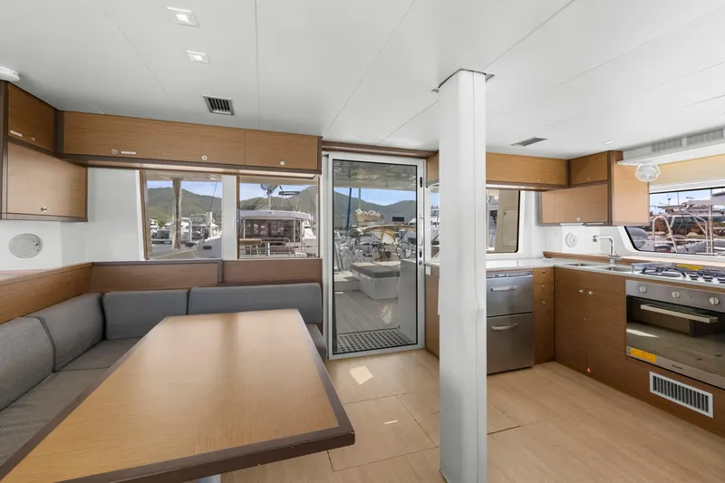 Happy Ours Yacht Photos Pics Modern interior of 2022 Lagoon 52 F yacht with kitchen and dining area.