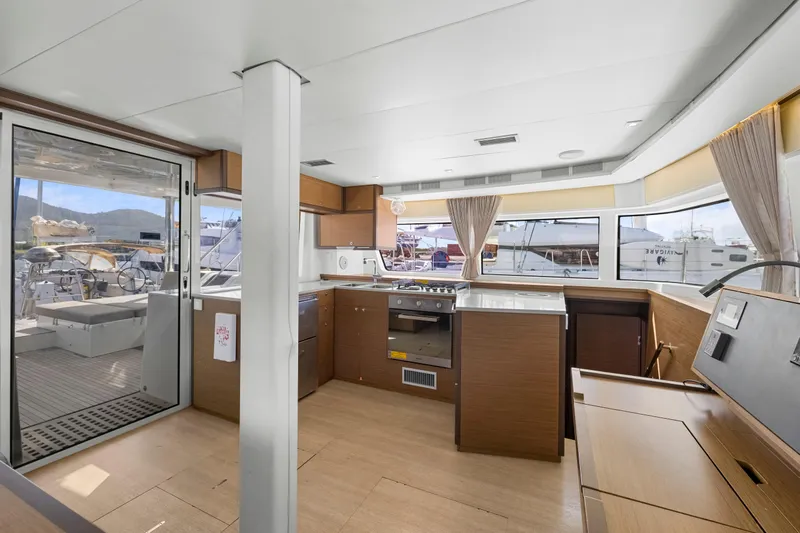 Happy Ours Yacht Photos Pics Interior of 2022 Lagoon 52 F yacht with modern kitchen and panoramic windows.
