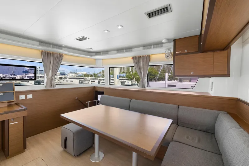 Happy Ours Yacht Photos Pics Interior of 2022 Lagoon 52 F yacht with modern dining area and large windows.