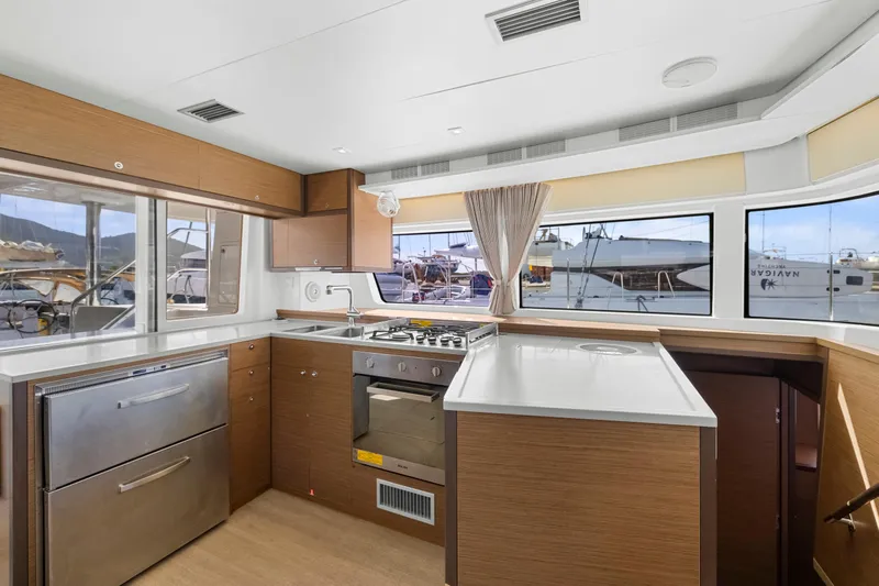 Happy Ours Yacht Photos Pics Modern kitchen interior on 2022 Lagoon 52 F yacht, featuring sleek cabinetry and stainless steel appliances.