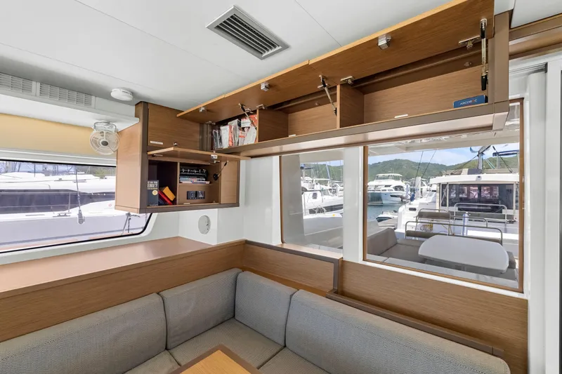 Happy Ours Yacht Photos Pics Interior of 2022 Lagoon 52 F yacht with open cabinets and marina view.