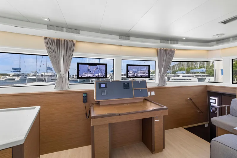 Happy Ours Yacht Photos Pics Interior of 2022 Lagoon 52 F yacht with navigation station and marina view.