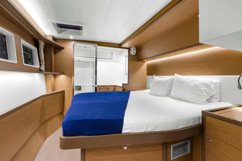 Happy Ours Yacht Photos Pics Luxurious cabin interior of 2022 Lagoon 52 F yacht with modern design and cozy bedding.