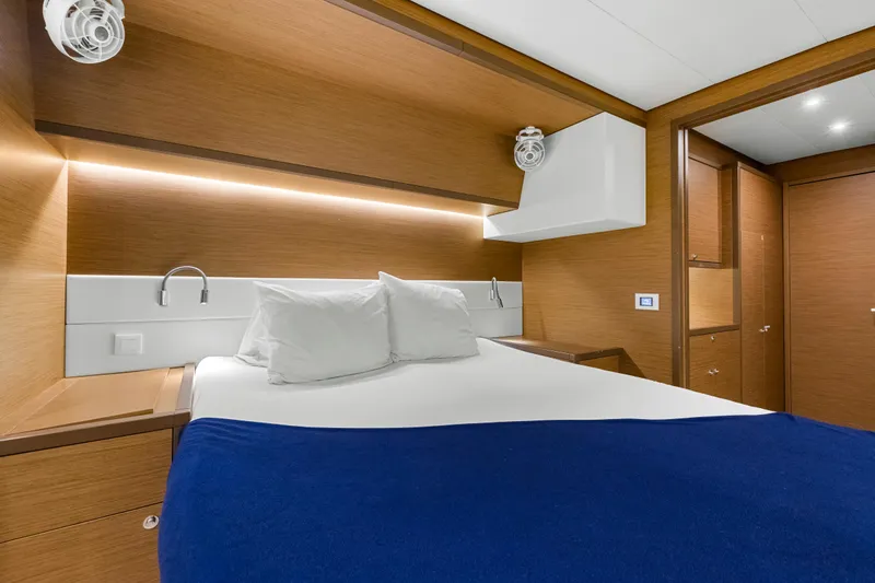 Happy Ours Yacht Photos Pics Luxurious cabin interior of 2022 Lagoon 52 F yacht with modern wood finish and cozy bedding.