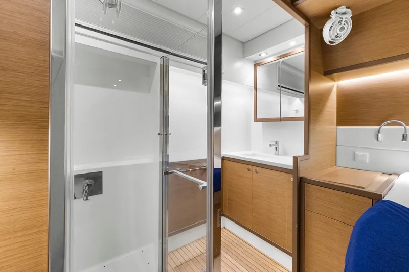 Happy Ours Yacht Photos Pics Luxurious bathroom interior of 2022 Lagoon 52 F yacht, featuring modern wood finishes and sleek design.