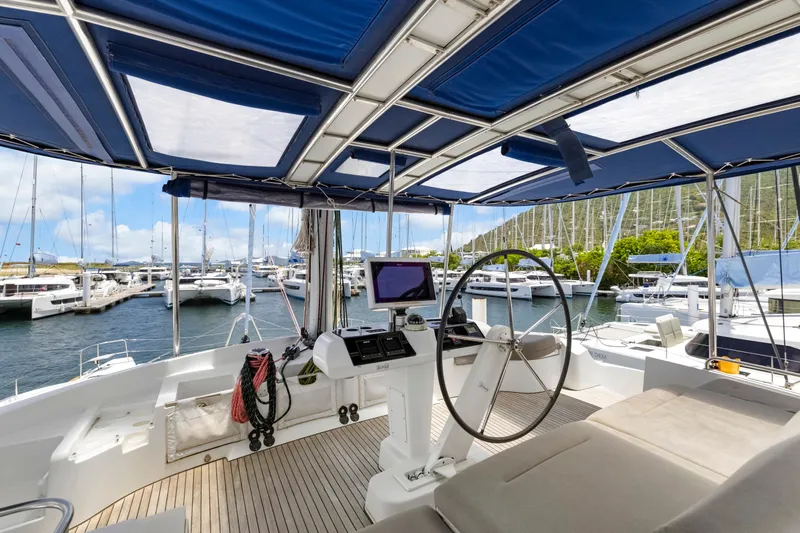 Happy Ours Yacht Photos Pics Interior view of 2022 Lagoon 52 F yacht helm, featuring modern navigation equipment and marina backdrop.
