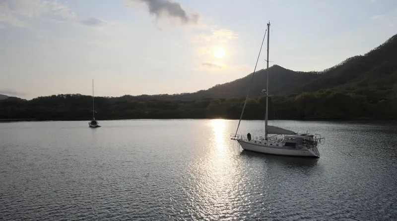 Via Yacht Photos Pics Sailboats on tranquil water at sunset, featuring a 2004 Caliber 40 LRC SE.