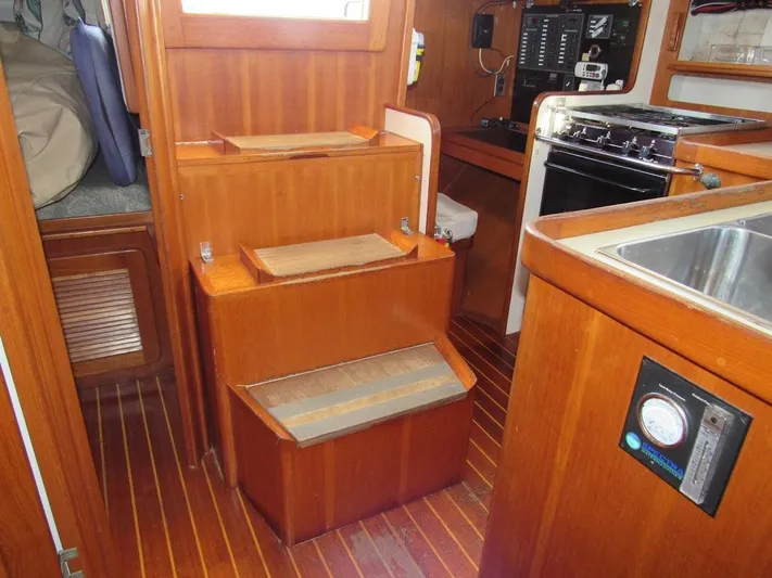 Via Yacht Photos Pics Interior of 2004 Caliber 40 LRC SE sailboat with wooden cabinetry and compact kitchen.