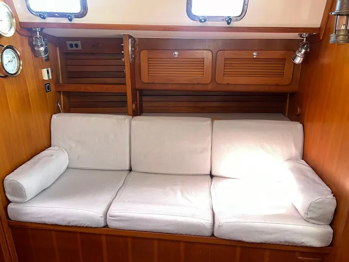 Via Yacht Photos Pics Interior of 2004 Caliber 40 LRC SE yacht with white cushioned seating and wooden cabinetry.