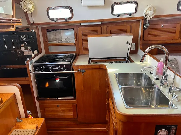 Via Yacht Photos Pics 2004 Caliber 40 LRC SE yacht kitchen with stove, double sink, and wooden cabinetry.