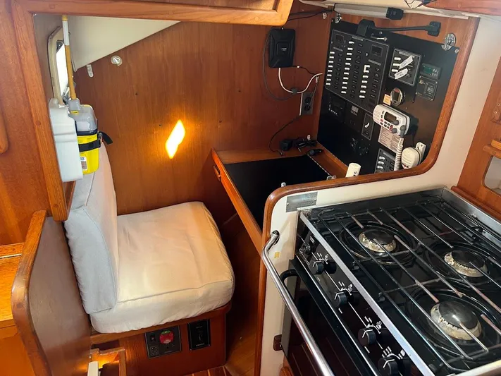 Via Yacht Photos Pics 2004 Caliber 40 LRC SE yacht interior with control panel, cushioned seat, and stove.