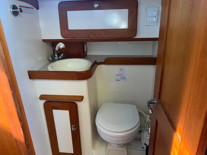 Via Yacht Photos Pics 2004 Caliber 40 LRC SE yacht bathroom with sink, toilet, and wooden accents.