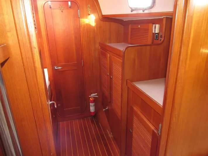 Via Yacht Photos Pics Wood-paneled interior of 2004 Caliber 40 LRC SE yacht, featuring cabinets and a fire extinguisher.