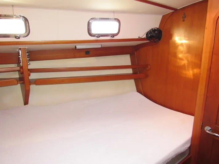 Via Yacht Photos Pics Cozy cabin interior of 2004 Caliber 40 LRC SE sailboat with wooden accents and bedding.