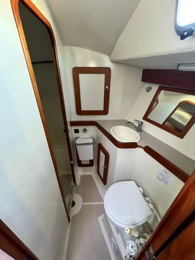 Via Yacht Photos Pics 2004 Caliber 40 LRC SE yacht bathroom with sink, toilet, and mirror.