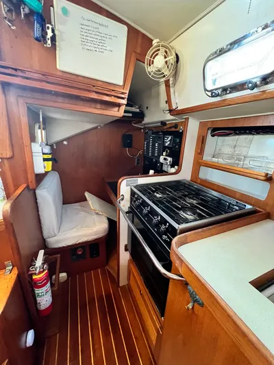 Via Yacht Photos Pics Compact kitchen area in a 2004 Caliber 40 LRC SE sailboat with stove and seating.