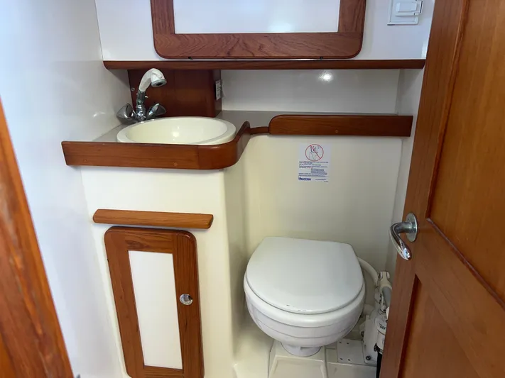 Via Yacht Photos Pics 2004 Caliber 40 LRC SE yacht bathroom with sink, toilet, and wooden accents.