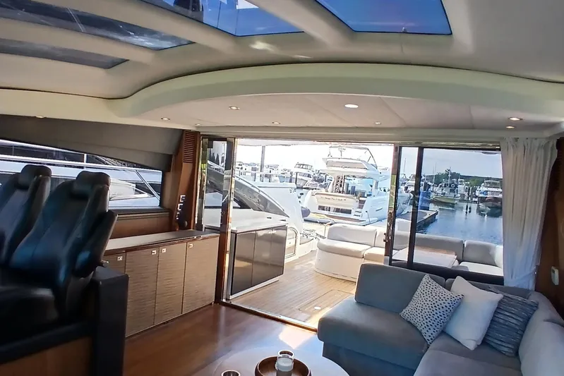  Yacht Photos Pics Luxurious interior of 2015 Princess V62-S yacht with marina view through glass doors.