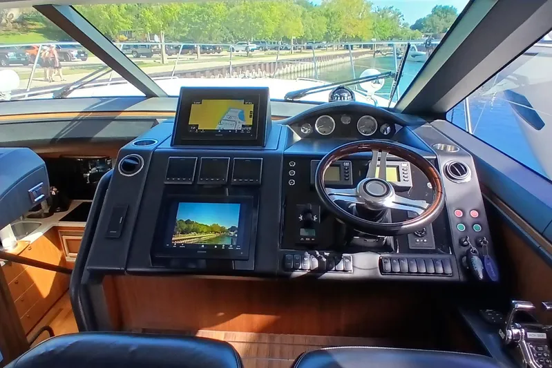  Yacht Photos Pics Cockpit of 2015 Princess V62-S yacht with navigation screens and steering wheel.
