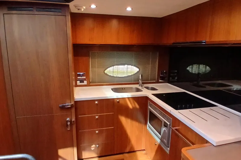  Yacht Photos Pics Luxurious 2015 Princess V62-S yacht kitchen with modern wood cabinetry and sleek appliances.