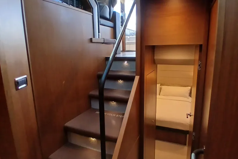  Yacht Photos Pics Interior of 2015 Princess V62-S yacht with wooden stairs and cozy bedroom.