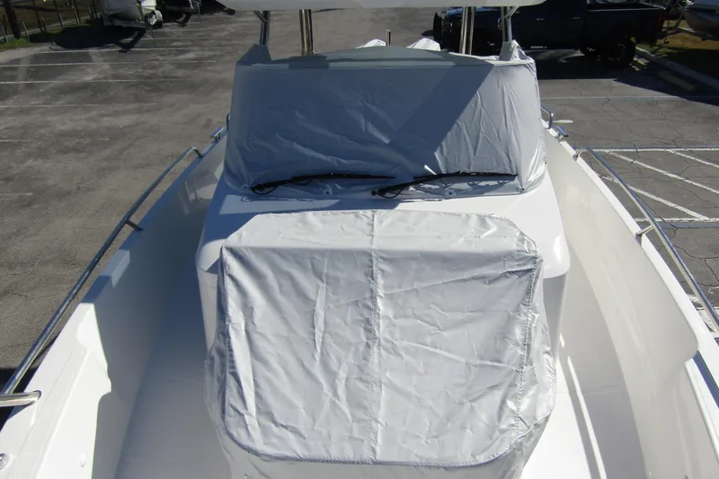  Yacht Photos Pics 2025 Nimbus Tender 9 boat with protective covers in a parking area.