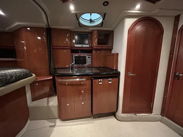 Yacht Photos Pics 2008 Four Winns V358 yacht interior with kitchenette, microwave, and wood cabinetry.