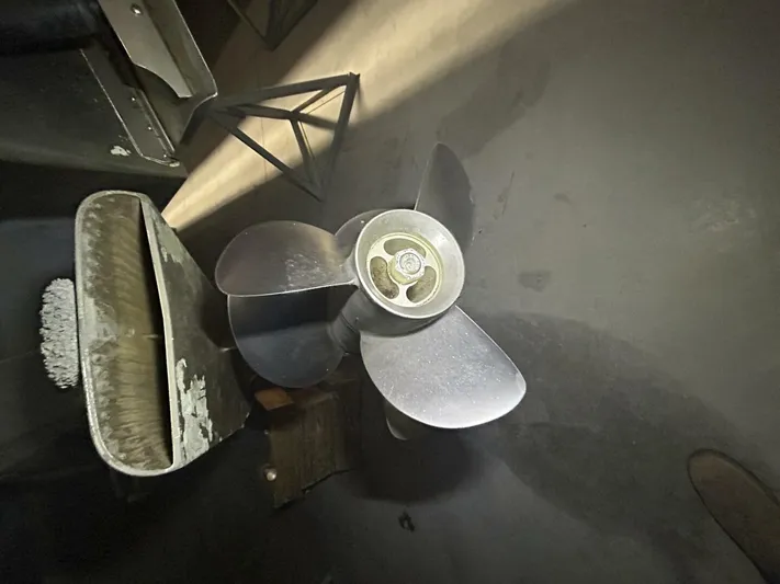  Yacht Photos Pics Four Winns V358 2008 boat propeller on a workshop floor, surrounded by tools.