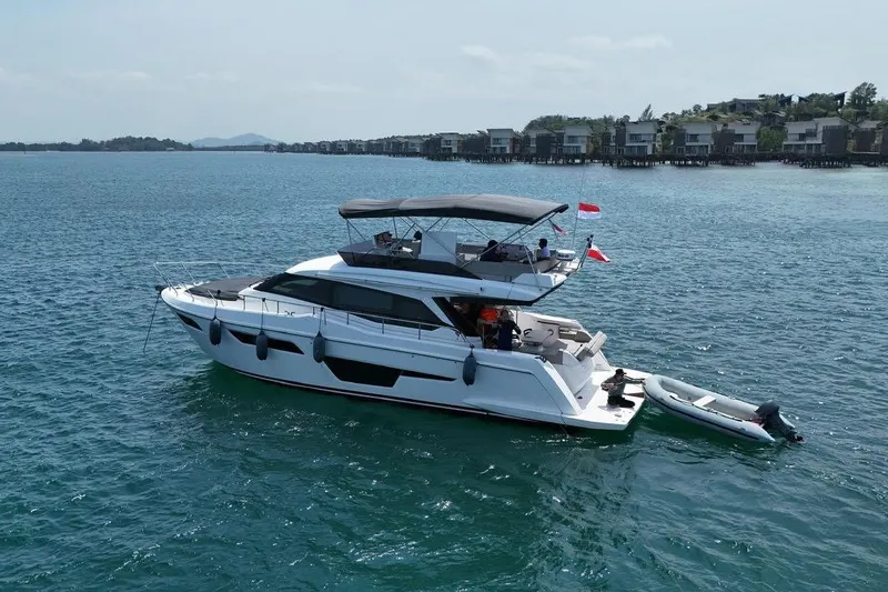  Yacht Photos Pics 2022 Ferretti Yachts 500 cruising on serene waters near coastal villas.
