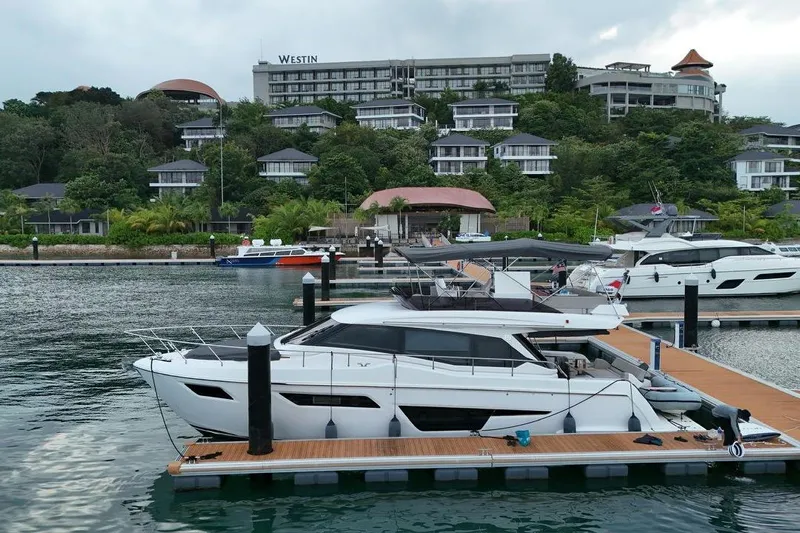  Yacht Photos Pics 2022 Ferretti Yachts 500 docked at marina, with luxury resort in the background.