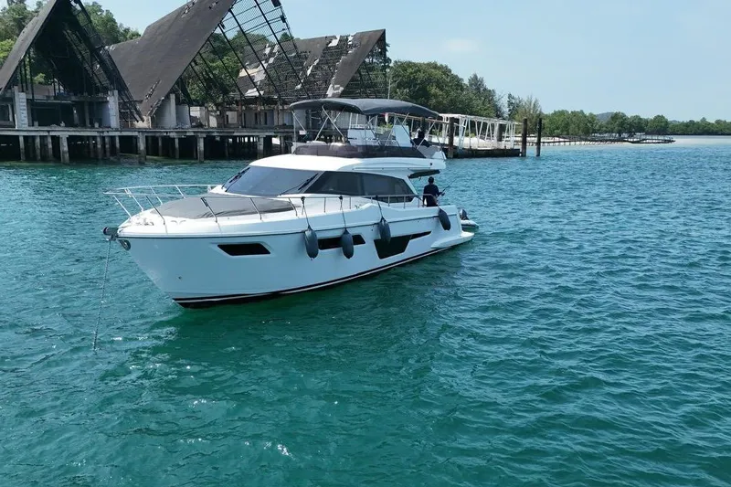  Yacht Photos Pics 2022 Ferretti Yachts 500 cruising on clear blue water near a dock.