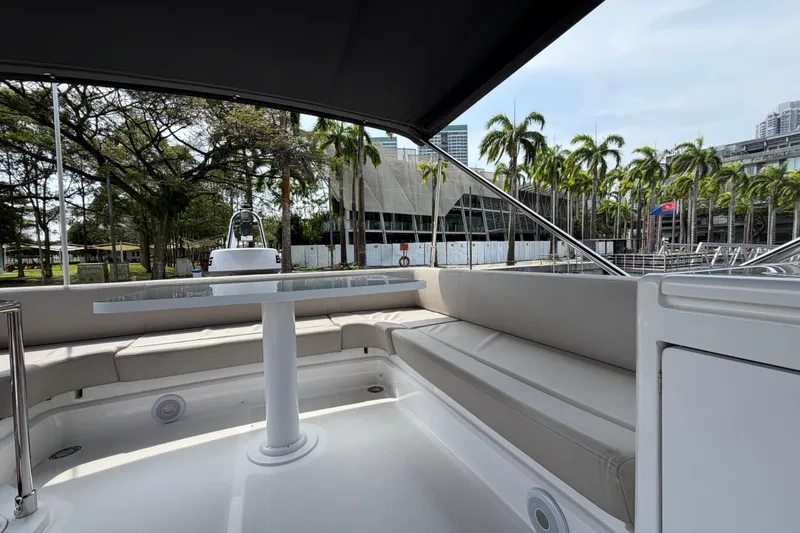  Yacht Photos Pics 2023 Ferretti Yachts 500 interior with seating and table, surrounded by palm trees.