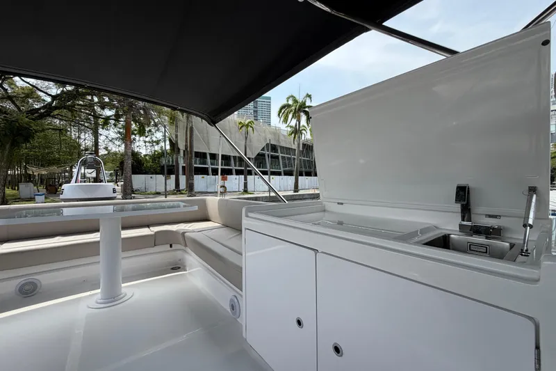  Yacht Photos Pics 2023 Ferretti Yachts 500 deck with seating and kitchenette under canopy.