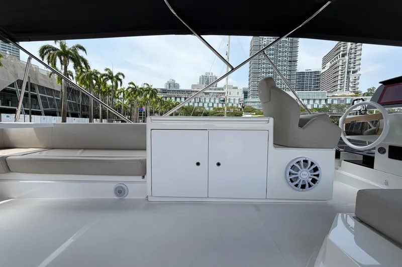  Yacht Photos Pics 2023 Ferretti Yachts 500 interior with seating, steering wheel, and cityscape background.