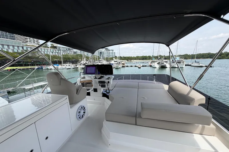 Yacht Photos Pics 2023 Ferretti Yachts 500 flybridge with seating, overlooking marina and docked boats.