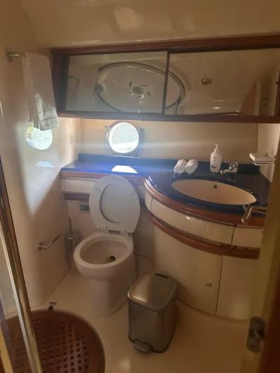  Yacht Photos Pics 2007 Azimut 55E yacht bathroom with toilet, sink, mirror, and porthole window.