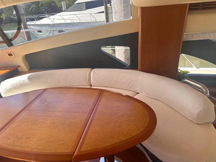  Yacht Photos Pics Luxurious interior of 2007 Azimut 55E yacht with elegant wood table and curved seating.